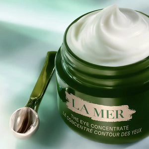 Open jar of La Mer The Eye Concentrate cream with a small applicator spoon on the side