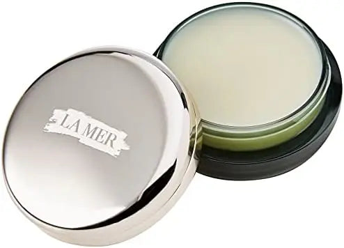 Open La Mer lip balm in a round silver container with smooth moisturizing balm inside
