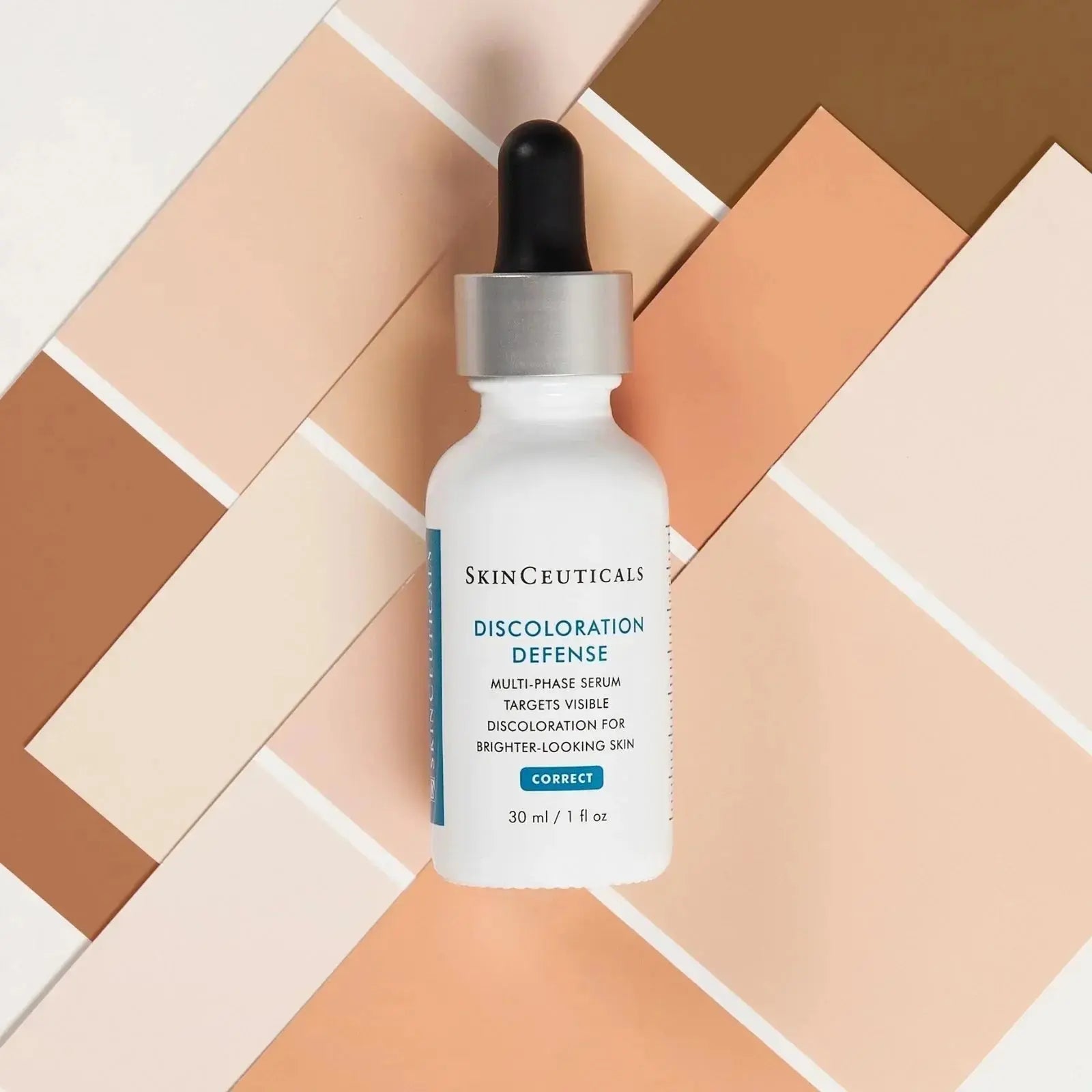 Skinceuticals Discoloration Defense Serum bottle with dropper on beige and brown geometric background