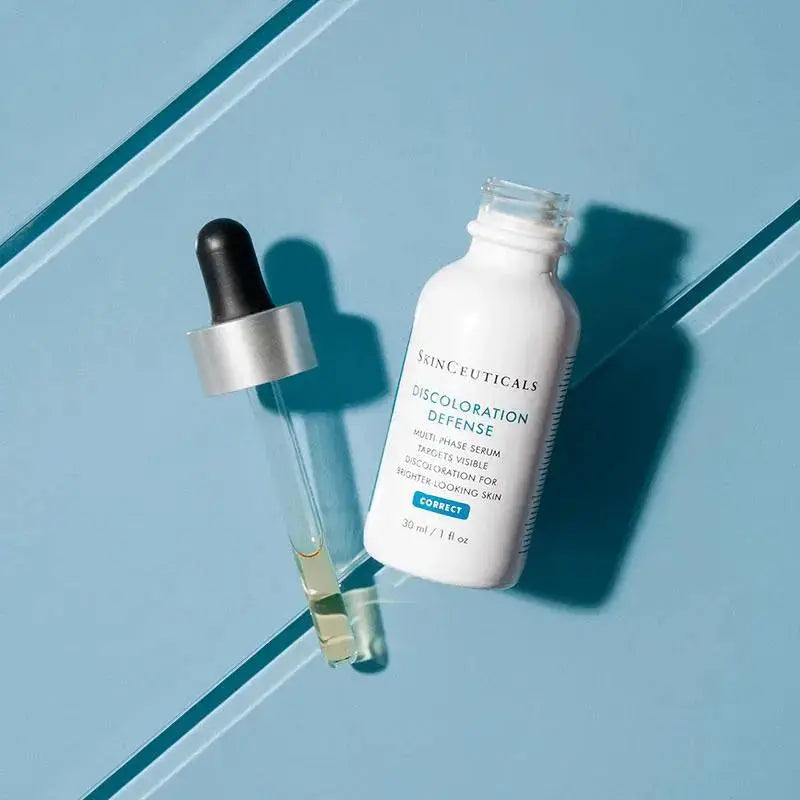Skinceuticals Discoloration Defense Serum bottle with dropper on blue background by Think AtoZ Ltd
