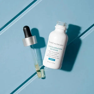 Skinceuticals Discoloration Defense Serum bottle with dropper on blue background by Think AtoZ Ltd