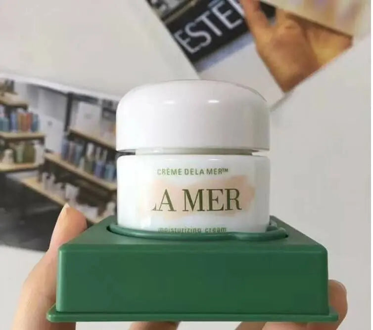 La Mer moisturizing cream wholesale in white jar with green packaging held in hand by Think AtoZ Ltd