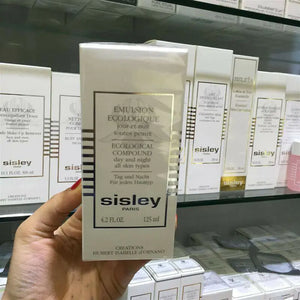 Sisley Ecological Compound day night cream in white box held in hand with skincare products in background