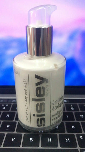 Sisley Ecological Compound day night cream bottle with pump dispenser on laptop keyboard